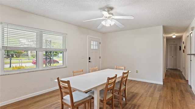 dining room featuring a textured ceiling, ceiling fan, and wood-type flooring