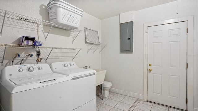 laundry room with light tile patterned flooring, washer and dryer, and electric panel