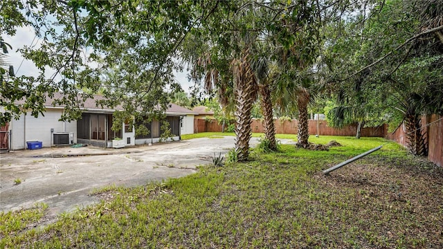 single story home featuring cooling unit and a front yard