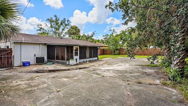 rear view of property with a patio area, a sunroom, and central AC unit