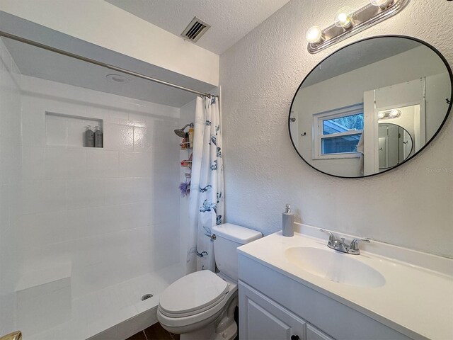 bathroom with vanity, a textured ceiling, a shower with shower curtain, and toilet