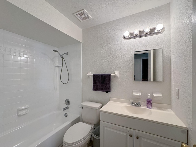 full bathroom with a textured ceiling, toilet, vanity, and tiled shower / bath