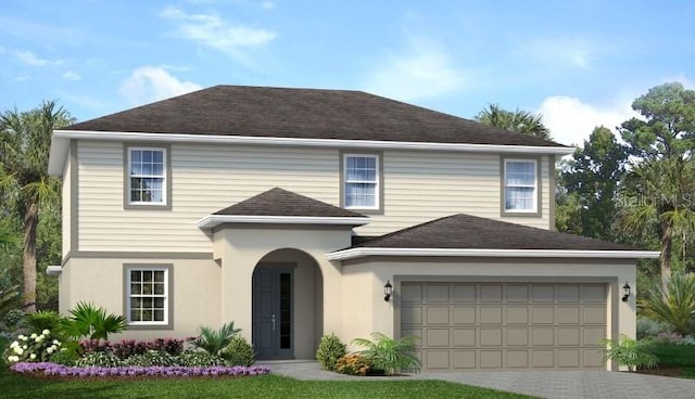 traditional home featuring stucco siding, an attached garage, driveway, and a shingled roof