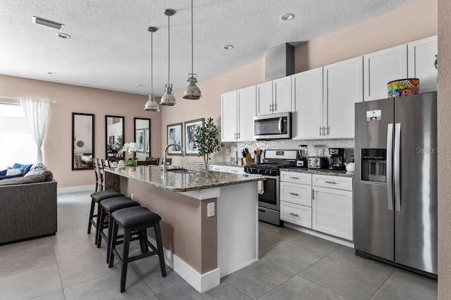 kitchen with plenty of natural light, appliances with stainless steel finishes, and white cabinets