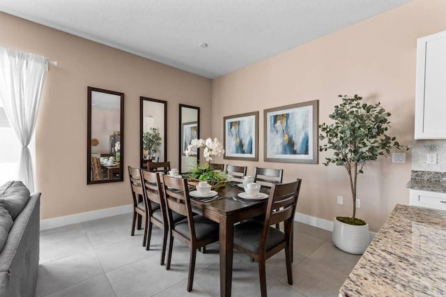 dining area featuring light tile patterned floors and a textured ceiling