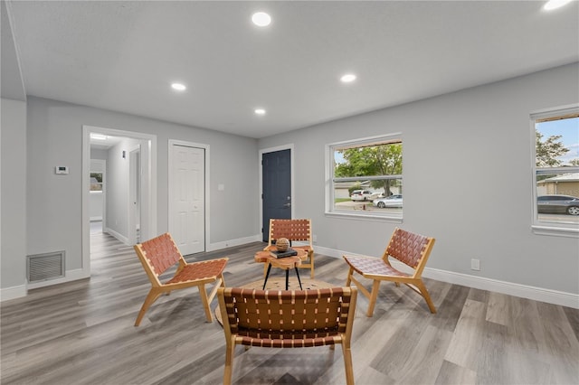 living area featuring baseboards, visible vents, wood finished floors, and recessed lighting