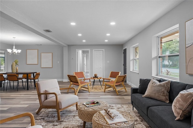 living area featuring a healthy amount of sunlight, light wood-style floors, baseboards, and visible vents