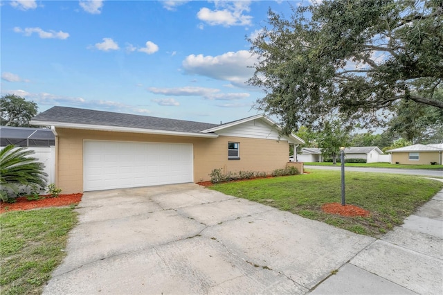 ranch-style home with an attached garage, driveway, a front yard, and concrete block siding