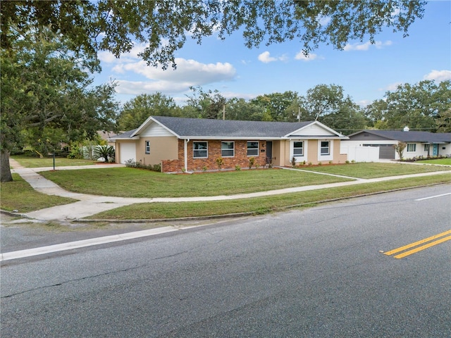 ranch-style home featuring a garage, brick siding, a front lawn, and fence