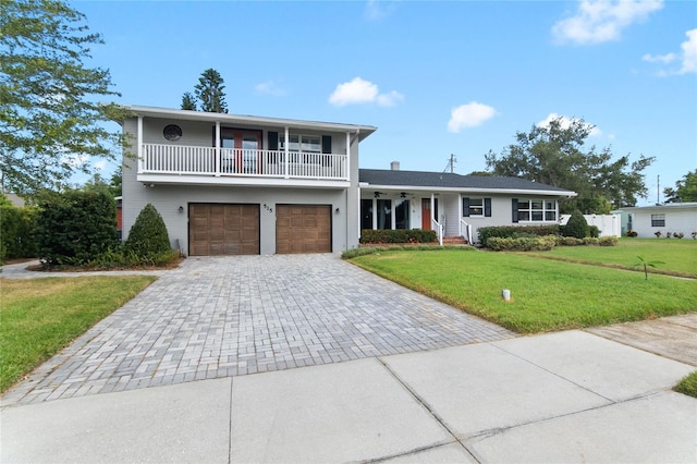 view of front of property featuring a garage, a balcony, and a front lawn