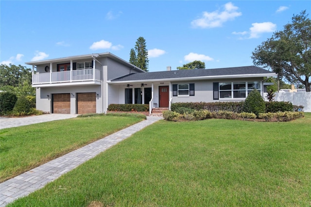 view of front of property featuring a garage, a balcony, and a front yard