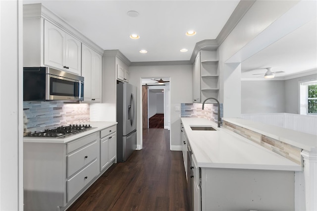 kitchen featuring stainless steel appliances, sink, backsplash, dark hardwood / wood-style floors, and ceiling fan