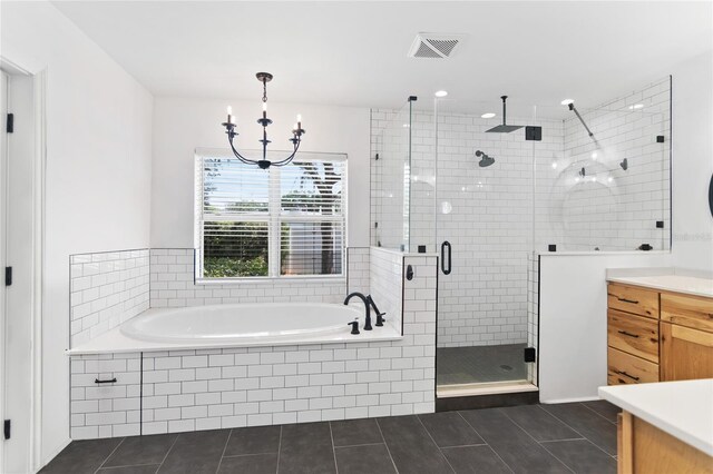 bathroom featuring tile patterned flooring, independent shower and bath, vanity, and an inviting chandelier