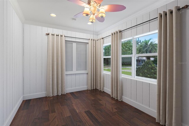 unfurnished room featuring ceiling fan, crown molding, dark hardwood / wood-style flooring, and plenty of natural light