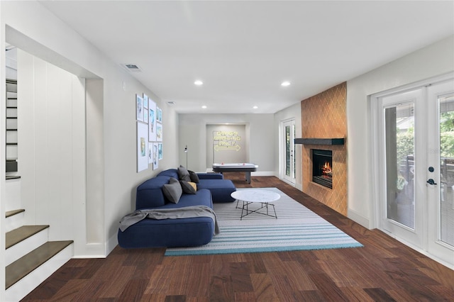 living room with a fireplace, french doors, and dark wood-type flooring