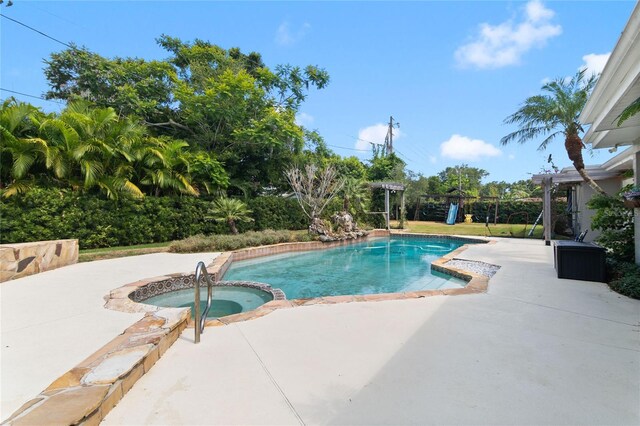 view of pool with an in ground hot tub and a patio