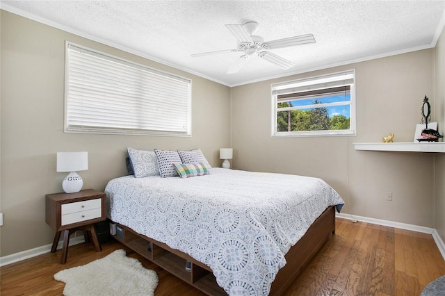 bedroom with crown molding, a textured ceiling, ceiling fan, and hardwood / wood-style floors