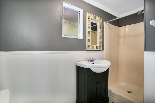 bathroom featuring a shower, vanity, and crown molding