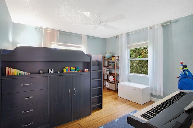 interior space featuring light hardwood / wood-style floors, a textured ceiling, and ceiling fan