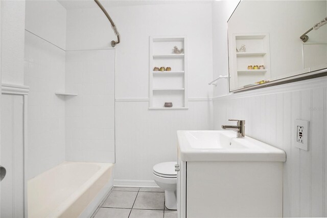 full bathroom featuring vanity, built in shelves, tiled shower / bath combo, toilet, and tile patterned flooring