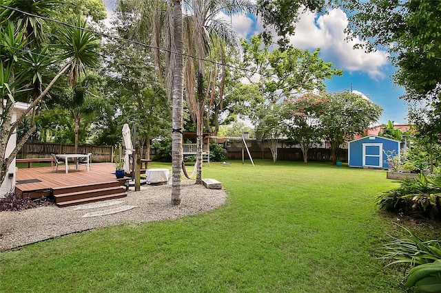 view of yard featuring a storage unit and a wooden deck