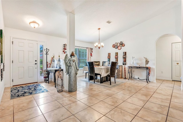 dining space with a notable chandelier and light tile patterned floors