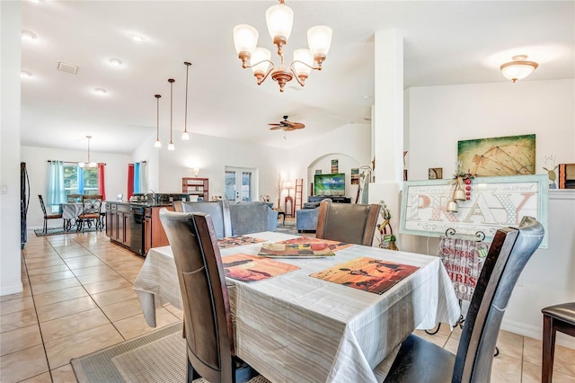 tiled dining area with ceiling fan with notable chandelier and lofted ceiling