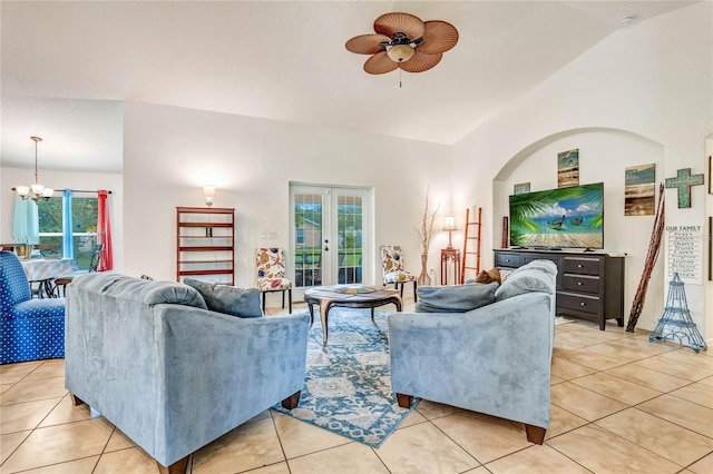 tiled living room featuring lofted ceiling, french doors, and ceiling fan with notable chandelier