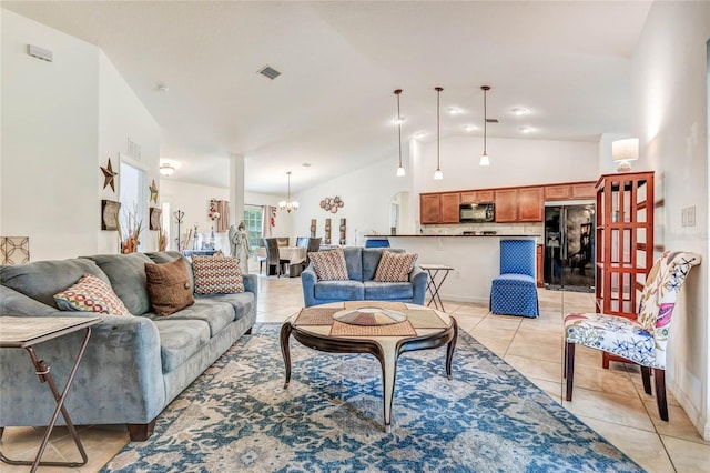 living room featuring a notable chandelier, light tile patterned floors, and vaulted ceiling