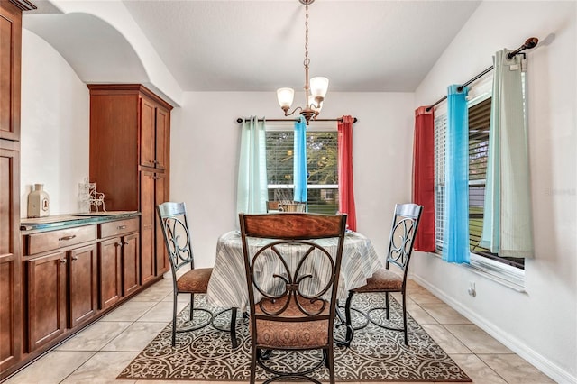 tiled dining space featuring a chandelier