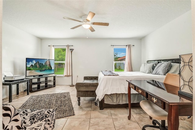 tiled bedroom featuring multiple windows, ceiling fan, and a textured ceiling