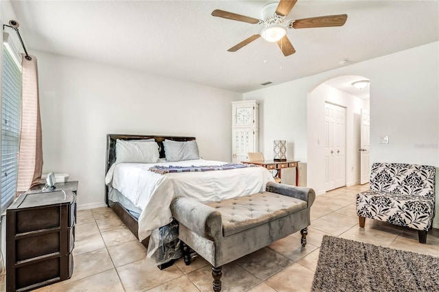 bedroom with light tile patterned floors, a closet, and ceiling fan