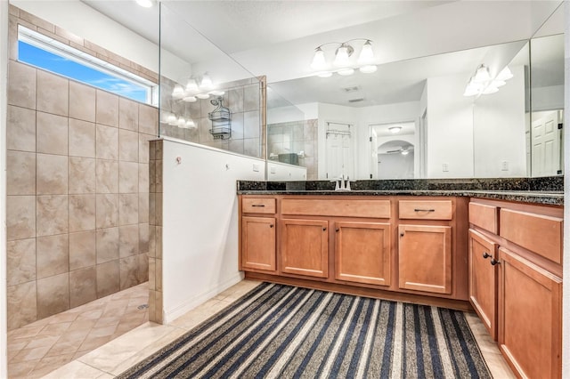 bathroom with a tile shower, tile patterned floors, and vanity