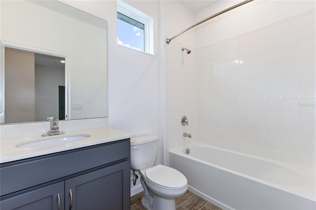 full bathroom featuring hardwood / wood-style flooring, tiled shower / bath combo, toilet, and vanity