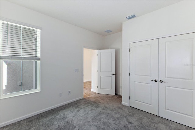 unfurnished bedroom with light carpet and a closet