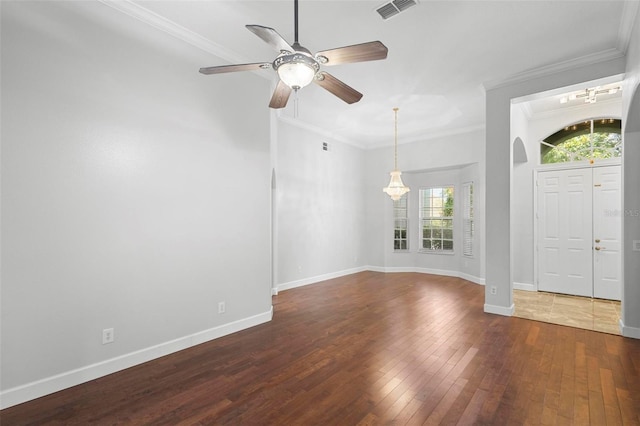 foyer with dark wood-type flooring, ceiling fan, plenty of natural light, and ornamental molding