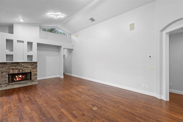 unfurnished living room featuring a textured ceiling, a stone fireplace, high vaulted ceiling, and dark hardwood / wood-style flooring