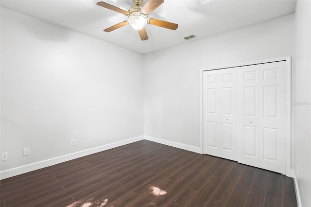 unfurnished bedroom with a closet, ceiling fan, and dark hardwood / wood-style flooring