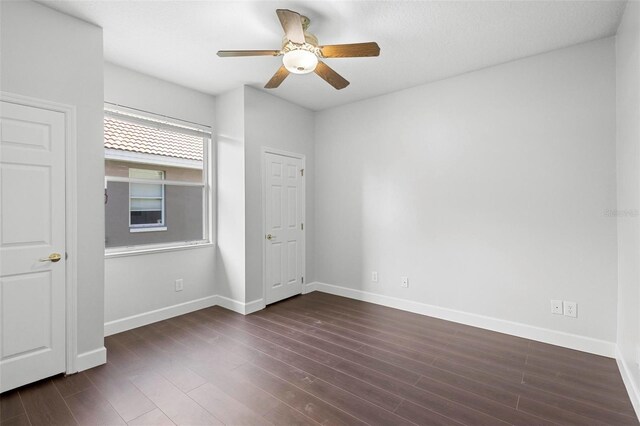 unfurnished bedroom with ceiling fan and dark hardwood / wood-style flooring