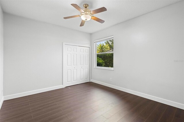 unfurnished room with dark hardwood / wood-style flooring and ceiling fan