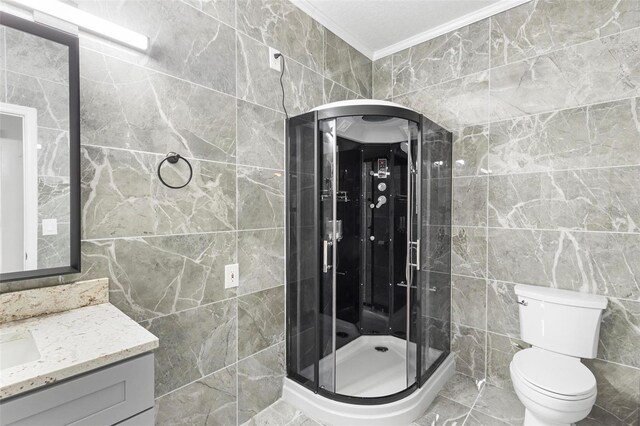 bathroom with vanity, walk in shower, tile walls, toilet, and ornamental molding