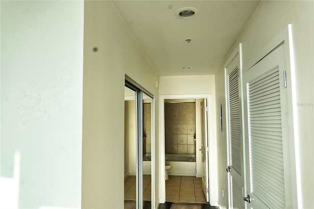 hall with tile patterned floors