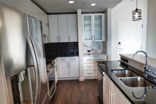 kitchen featuring pendant lighting, sink, white cabinets, backsplash, and stainless steel appliances