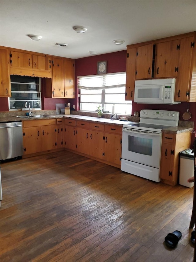 kitchen featuring sink, white appliances, and dark wood-type flooring