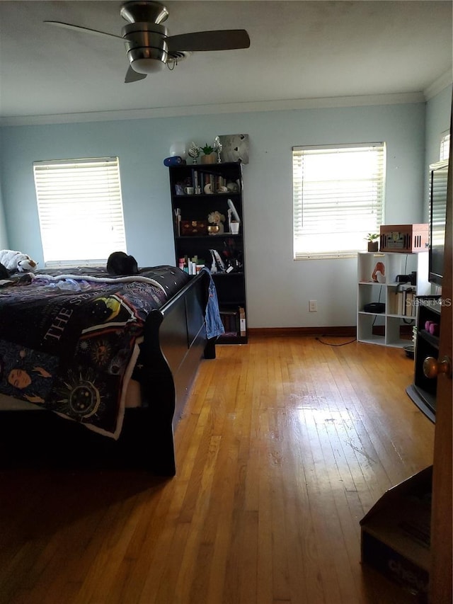 bedroom with crown molding, ceiling fan, and light hardwood / wood-style flooring