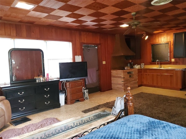 bedroom with sink, wooden walls, and ceiling fan