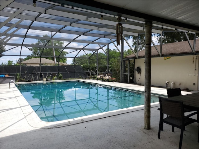 view of swimming pool with a patio area and glass enclosure