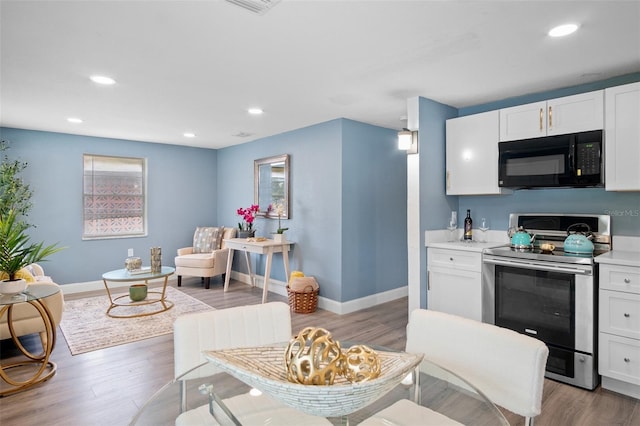 kitchen featuring white cabinetry, stainless steel electric range oven, and wood-type flooring