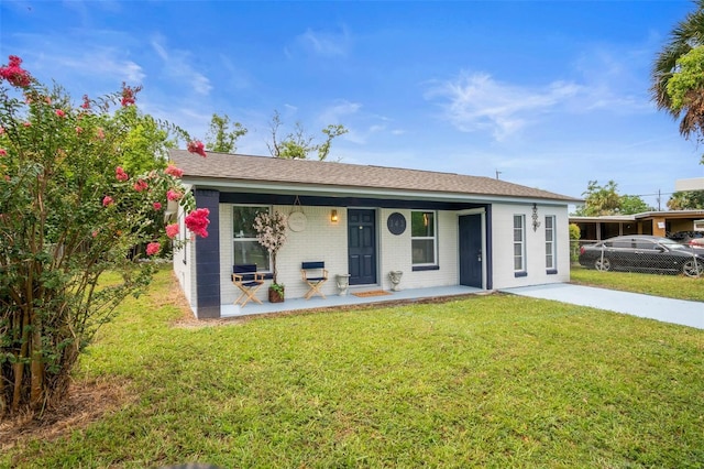 ranch-style house featuring brick siding, covered porch, a front yard, and fence