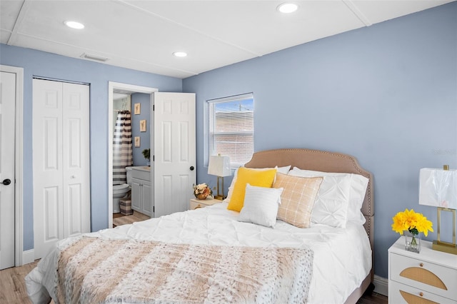 bedroom featuring ensuite bath and light hardwood / wood-style floors